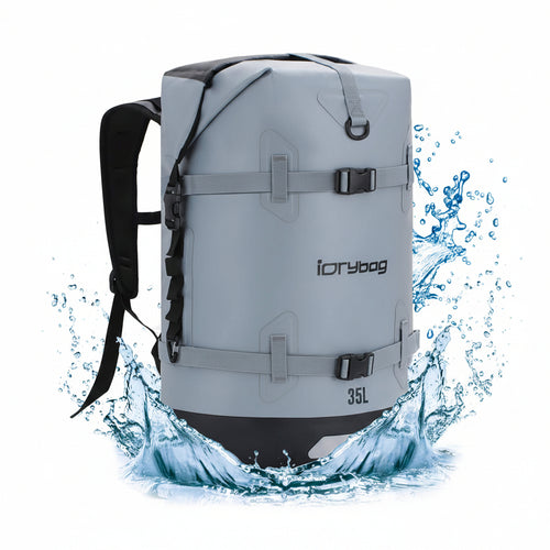 Gray backpack with black accents and 'iDrybag' branding, surrounded by water splashes on a white background.